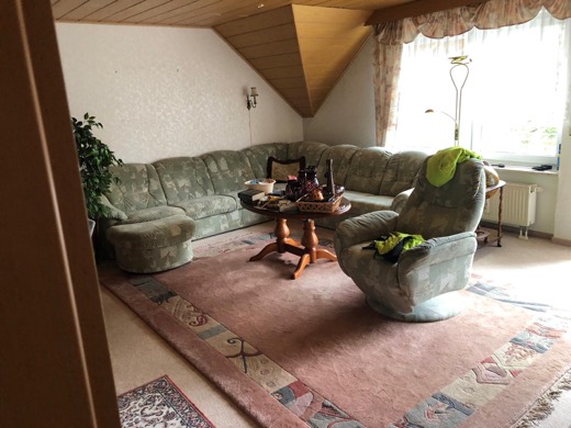 Wohnzimmer mit Sofa, Sessel und Teppichen